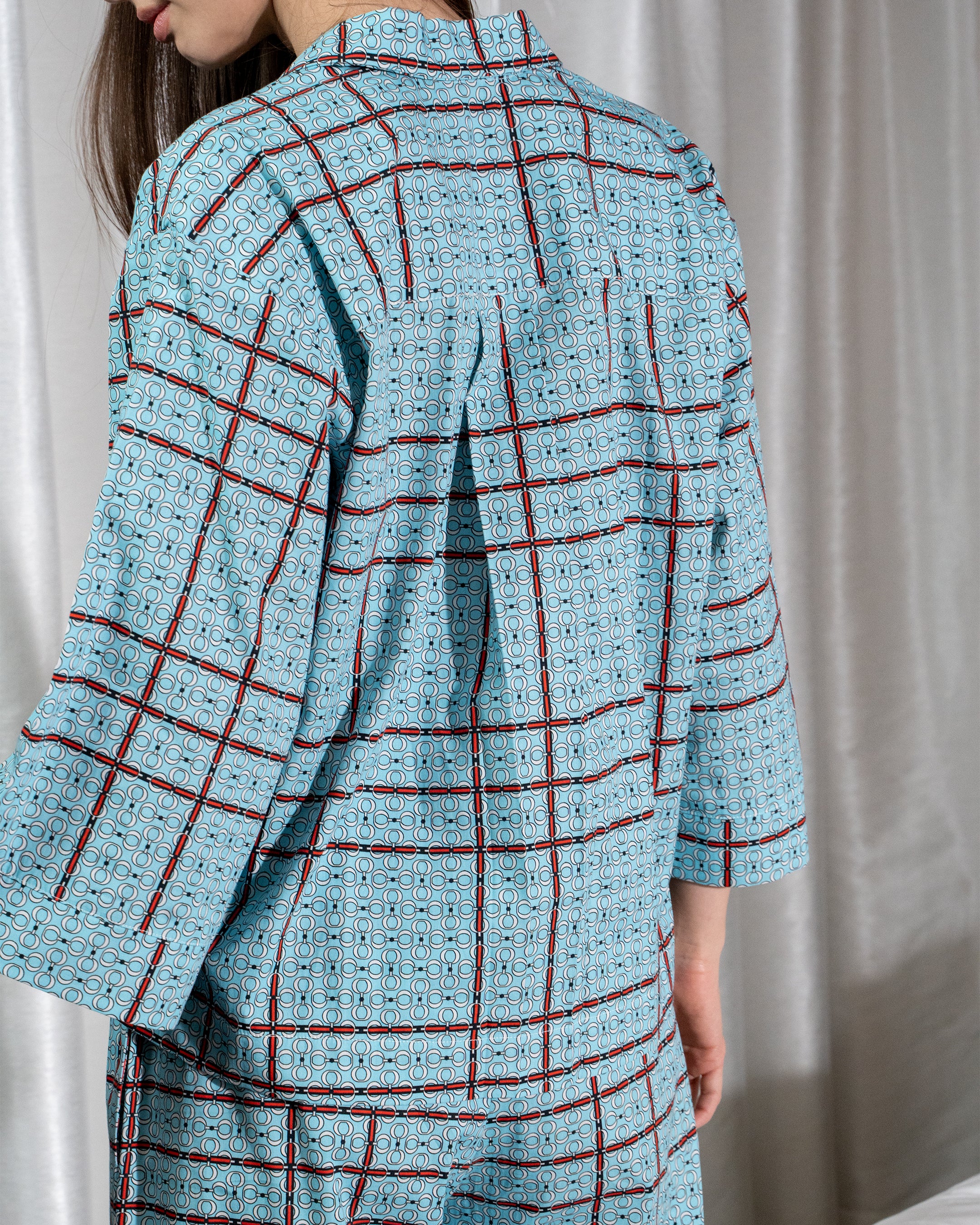Person wearing a blue checkered outfit with a plain background