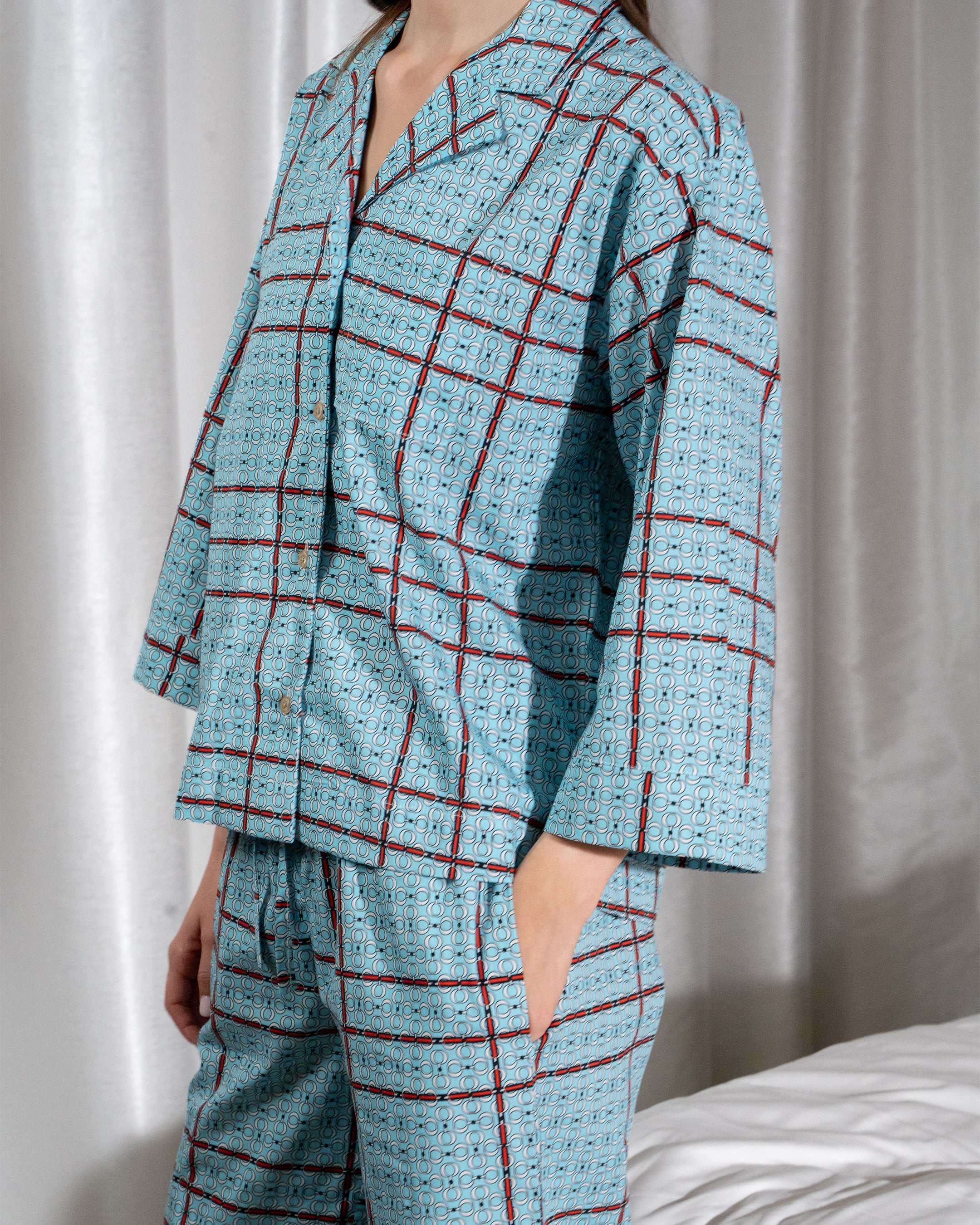 Person wearing a blue and red checkered pajama set against a neutral background
